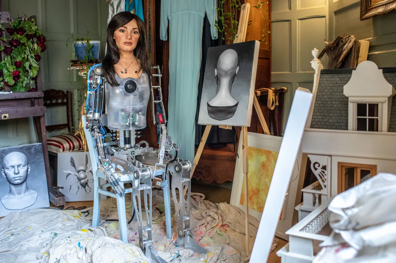 Ai-Da with her paintings. Photography by Victor Frankowski