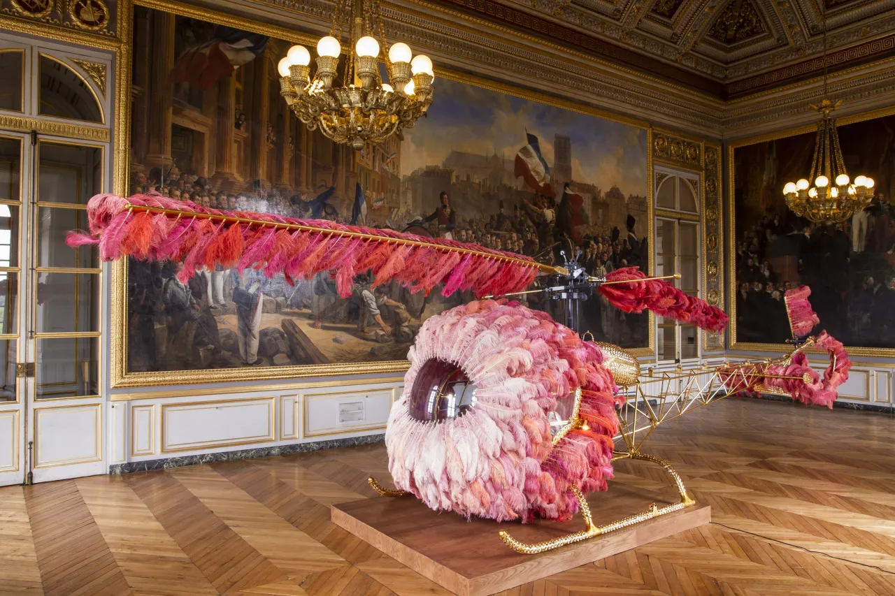 Joana Vasconcelos –
Lilicoptère, 2012 Helicóptero Bell 47, plumas de avestruz, cristales de Swarovski, pan de oro, pintura industrial, tapizado de cuero teñido repujado en oro fino, alfombras de Arraiolos, madera de nogal, pintura efecto madera y pasamanería 300 x 274 x 1265 cm Colección particular