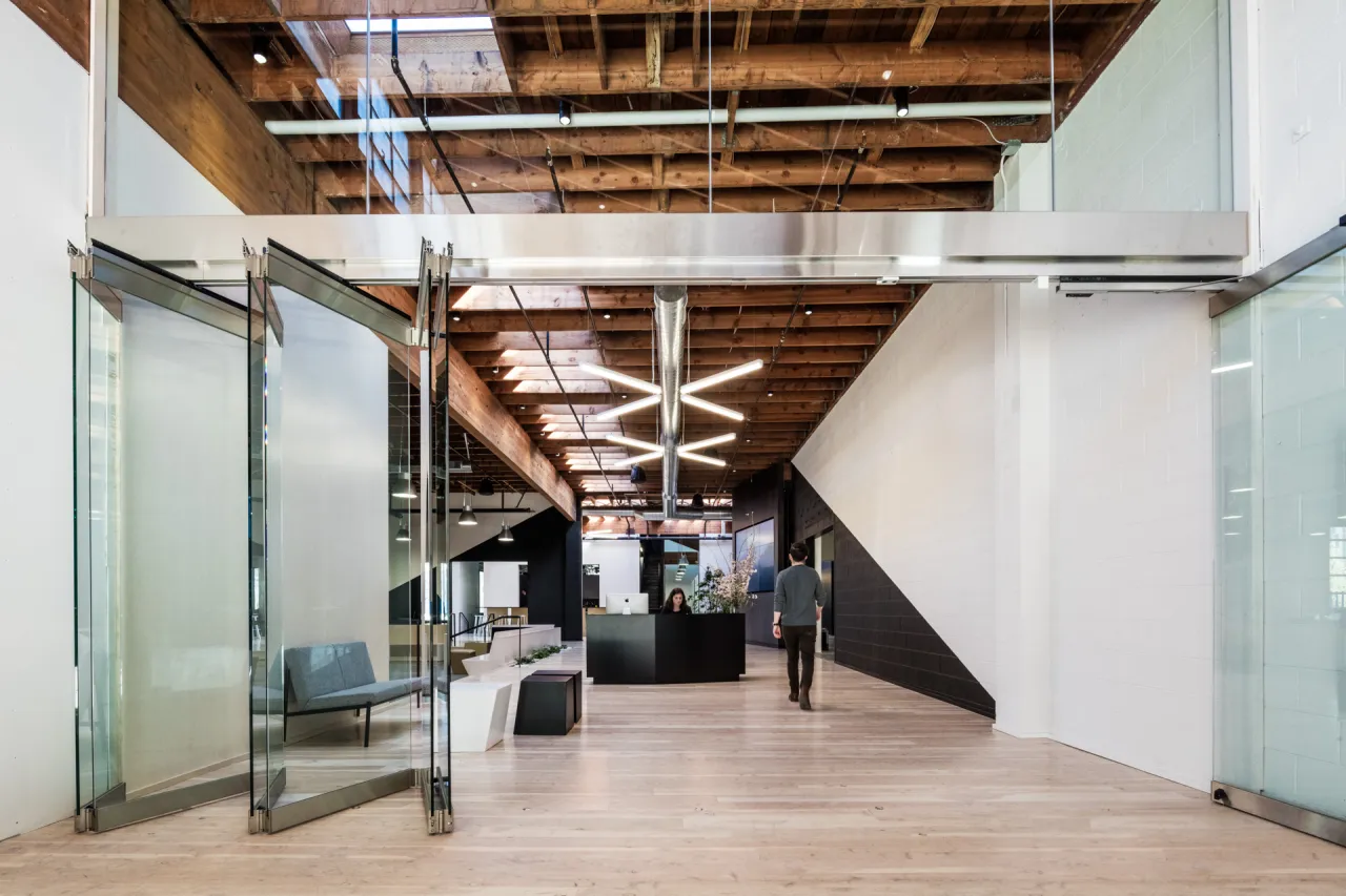 Swift Main Entrance: A glass accordion door folds flat to join the reception area and covered courtyard entryway.