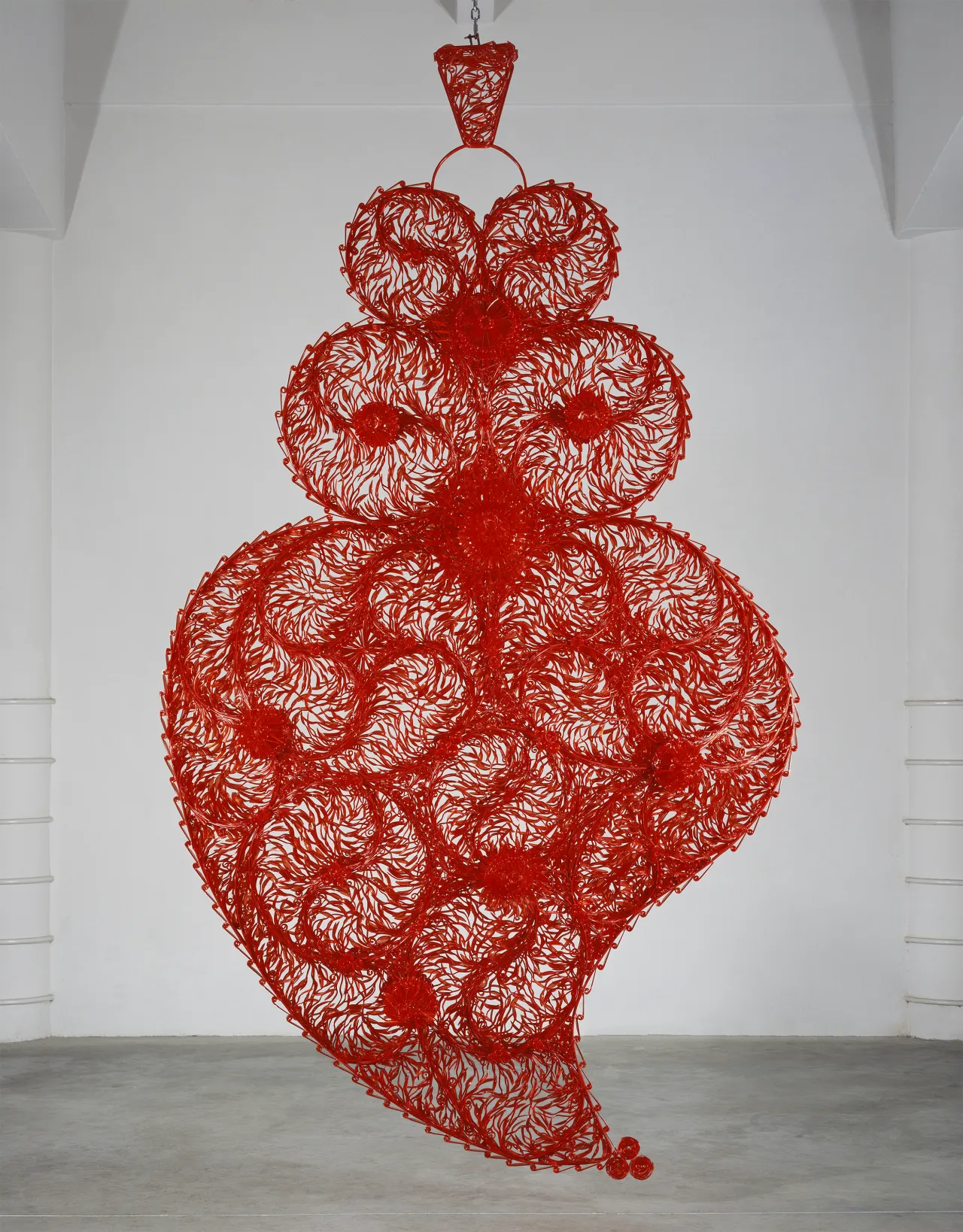Joana Vasconcelos –
Corazón independiente rojo (Coração Independente Vermelho), 2005 Cubiertos de plástico translúcido rojo, hierro pintado, cadena de metal, fuente de alimentación, motor e instalación sonora 371 x 220 x 75 cm Museu Colecção Berardo