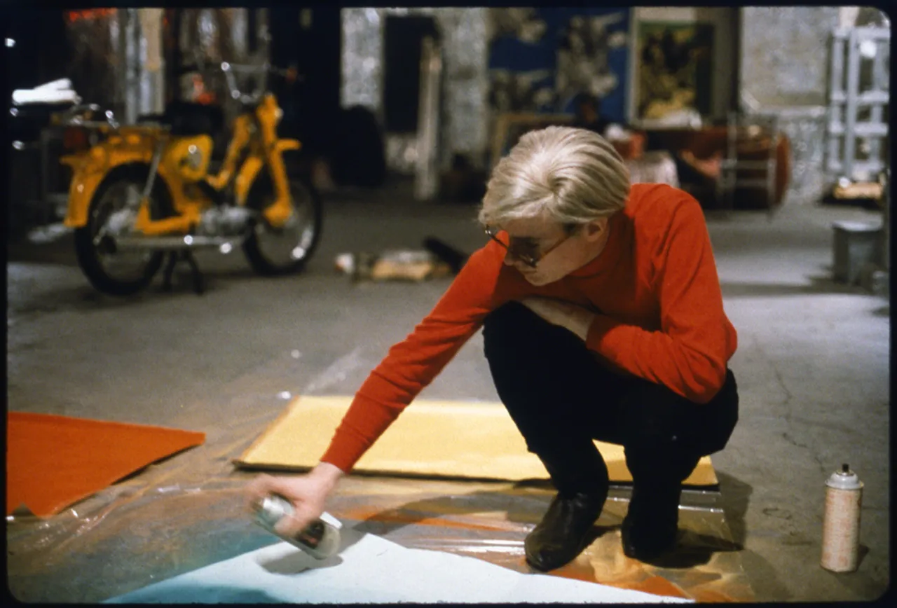 ‘Andy with Spray Paint and Moped’, The Factory, New York, 1965. © Nat Finkelstein Estate